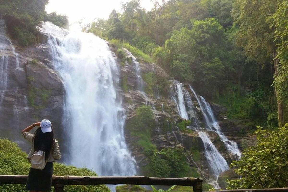 a woman standing in front of a waterfall