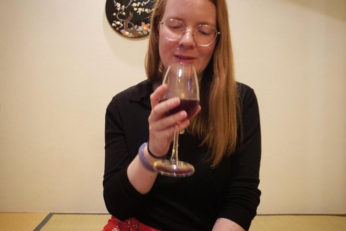 una donna che tiene in mano un bicchiere di vino rosso