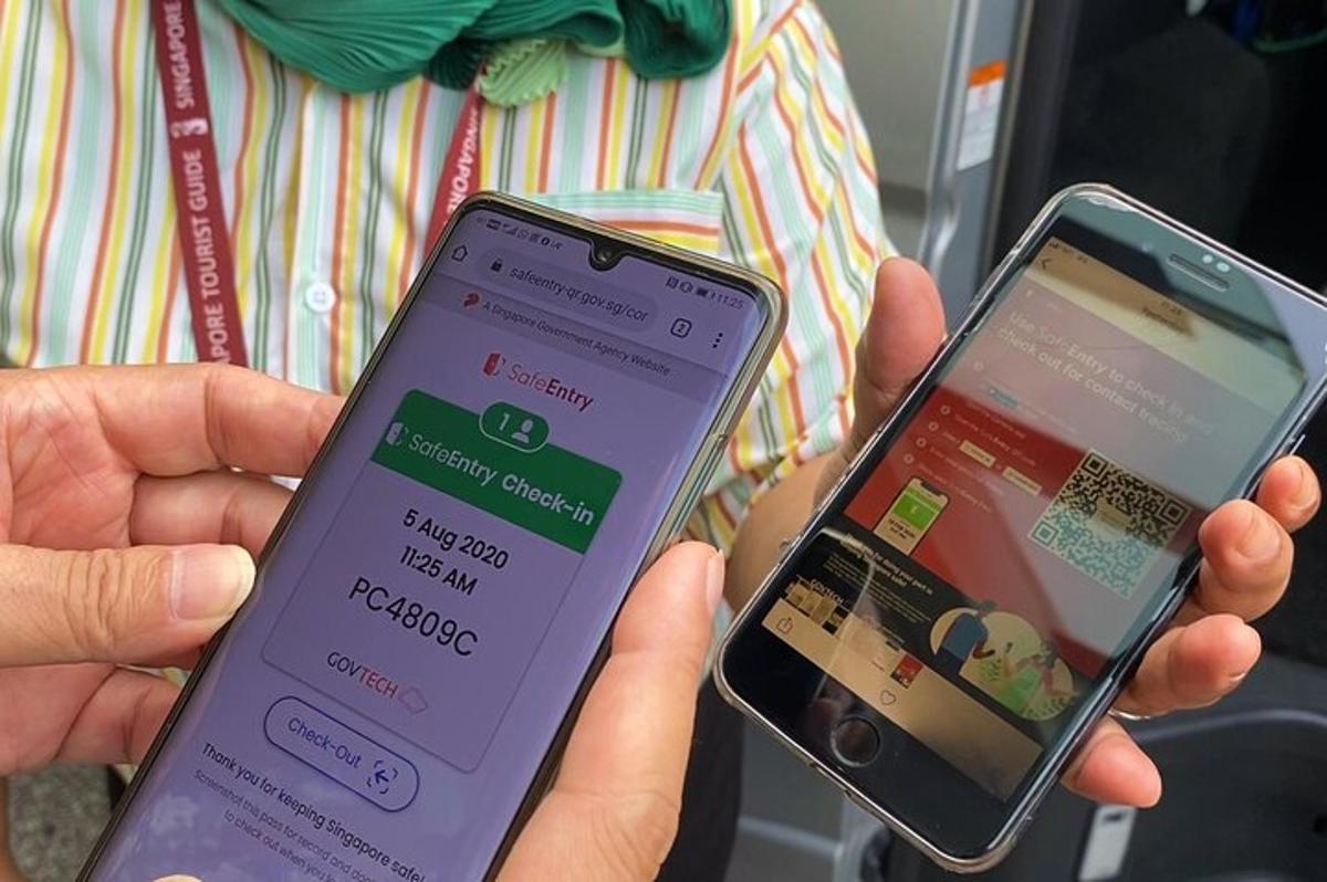 osoba držící v rukou dva mobilní telefony