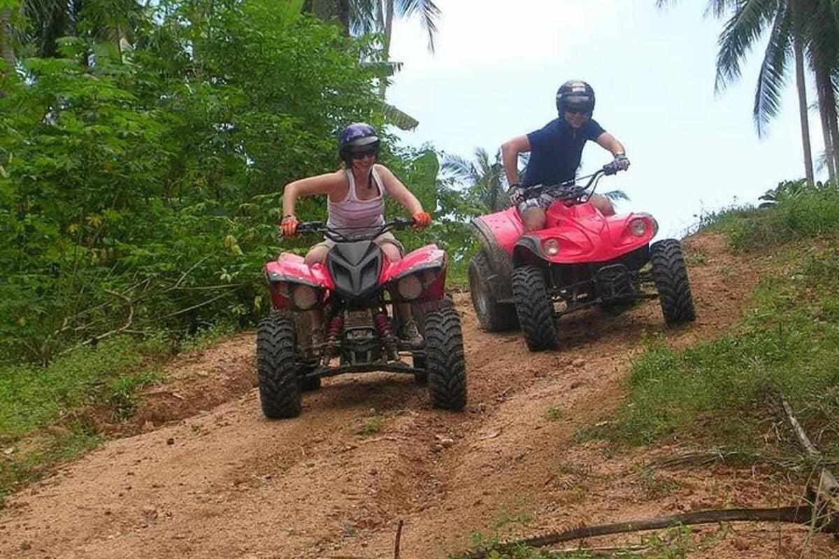 dvoje ljudi voze se na ATV-ima po zemljanom putu