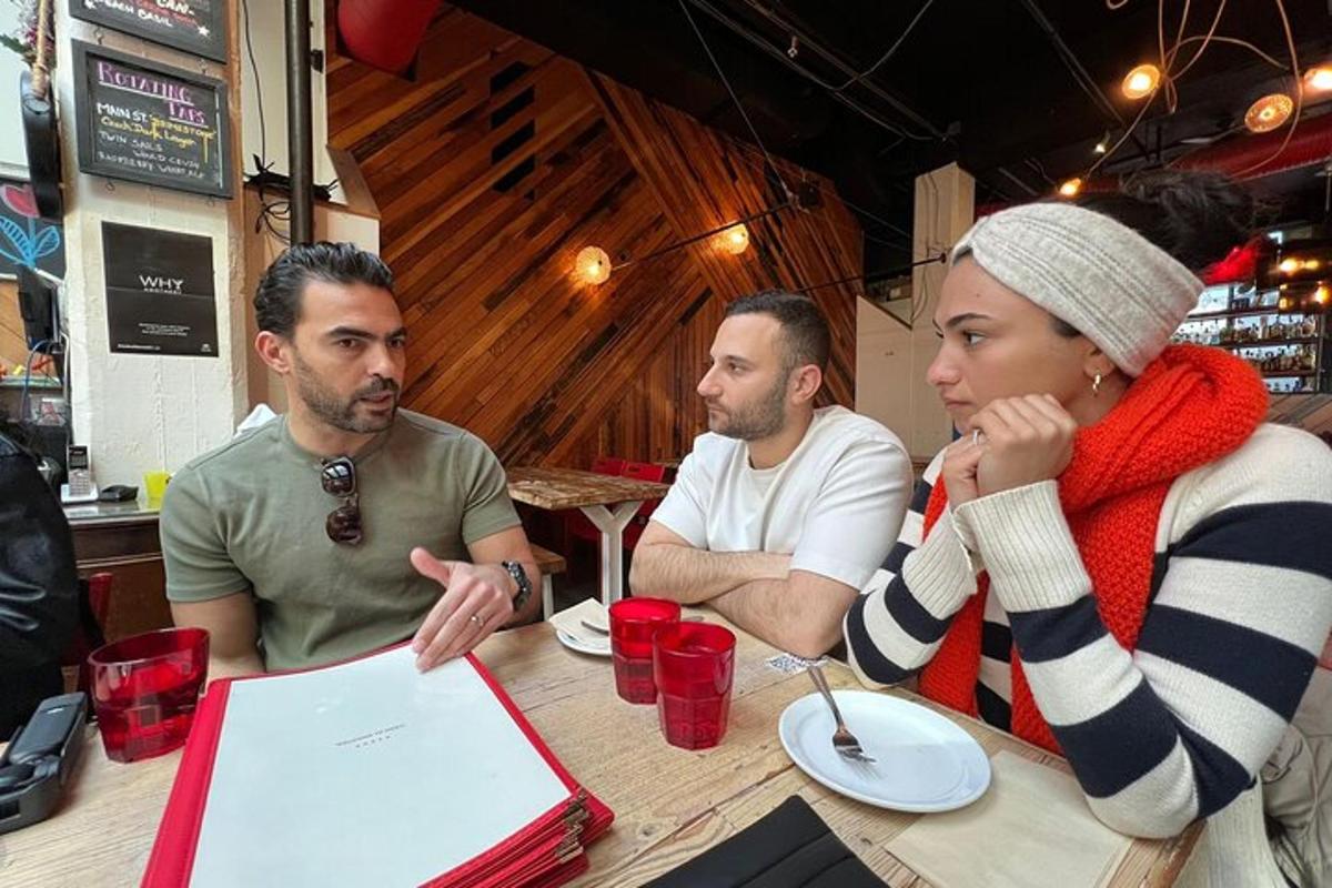 en grupp människor som sitter vid ett bord med en bärbar dator