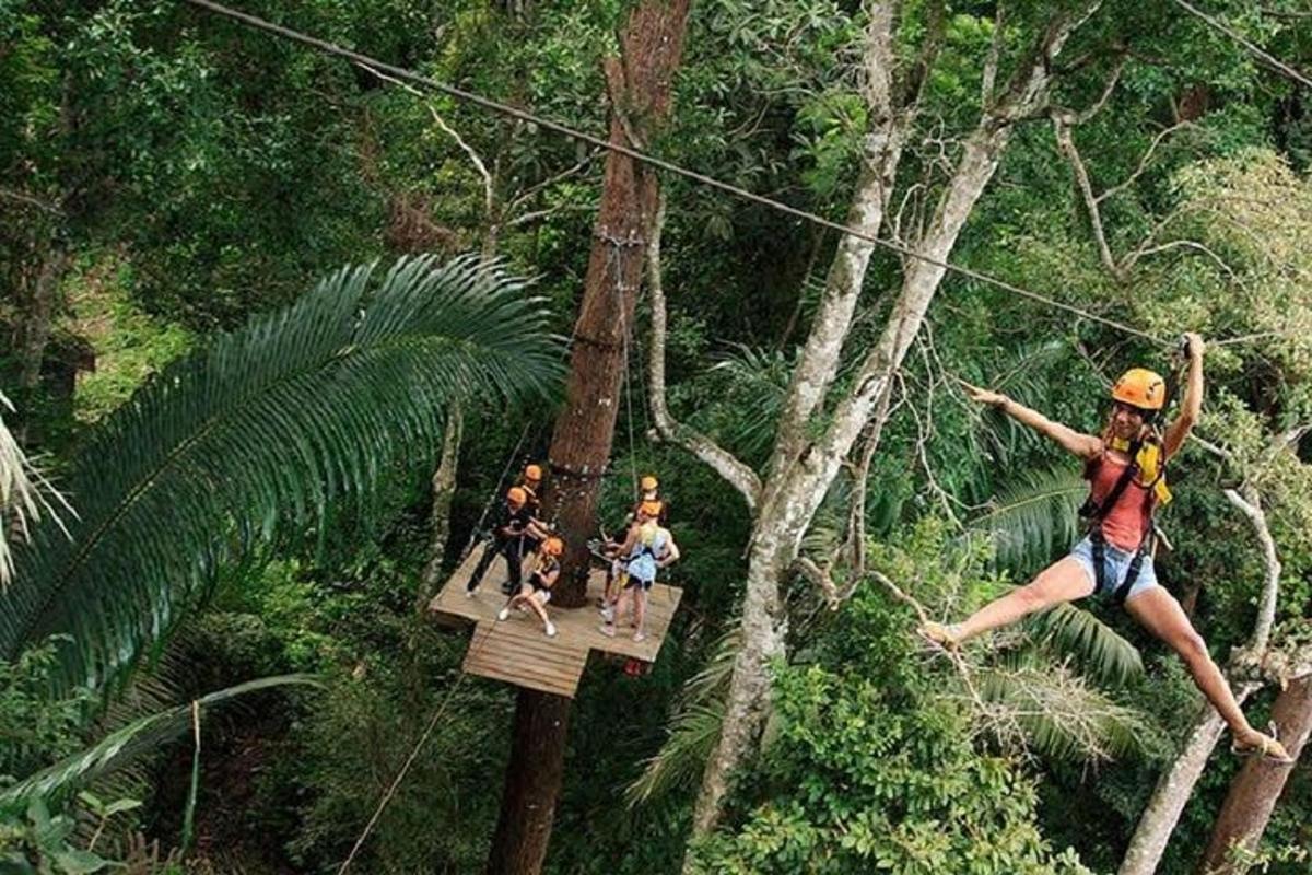 sekelompok orang di jalur zipline di hutan
