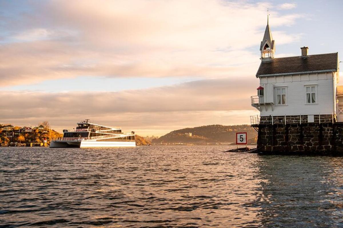 a cruise ship in the water next to a lighthouse