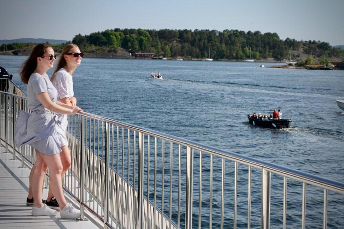 two women standing on a bridge with a boat in the water