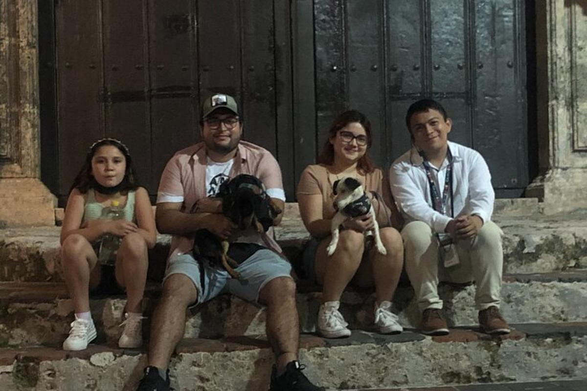 a group of people sitting on steps with their dogs