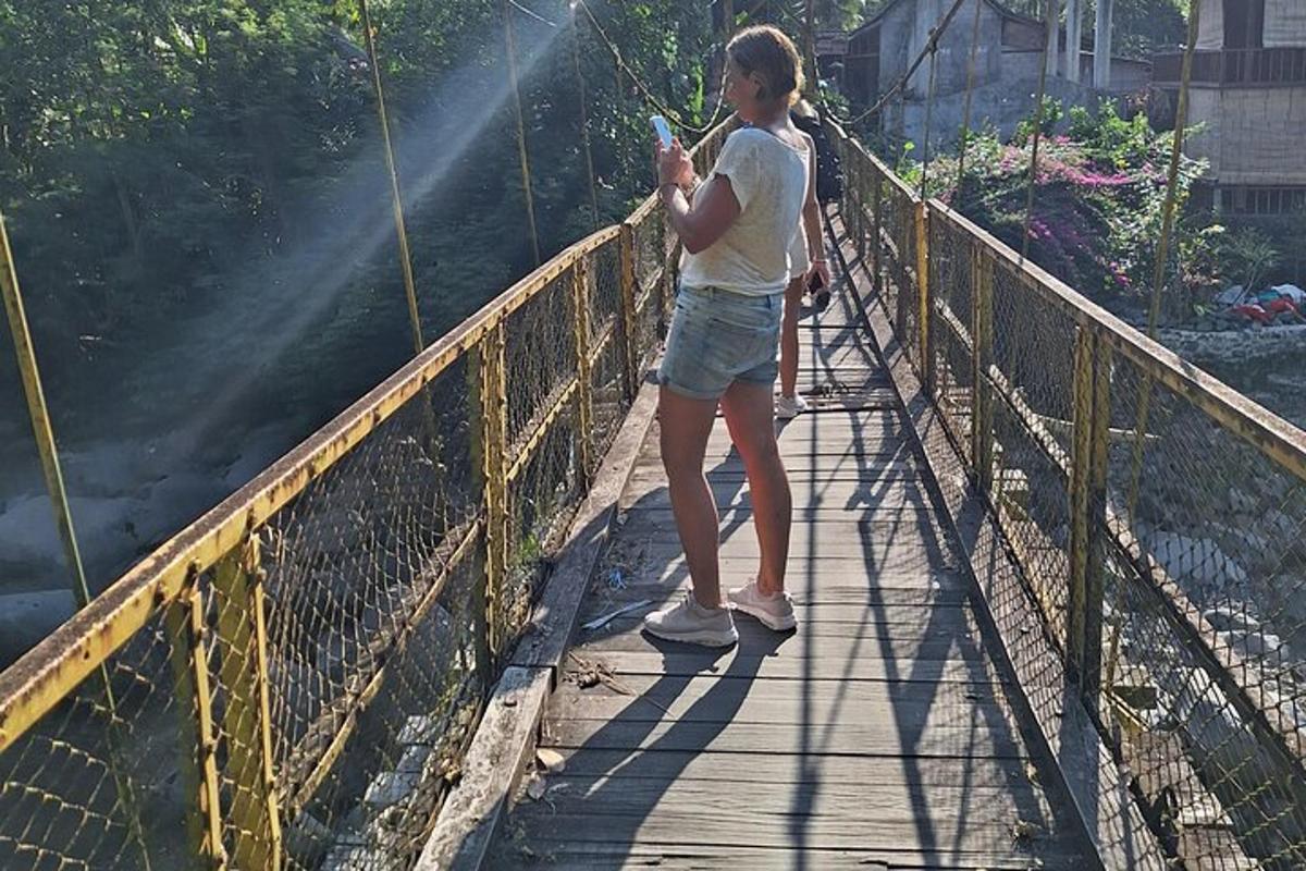 kona stendur á brú og horfir á farsímann sinn