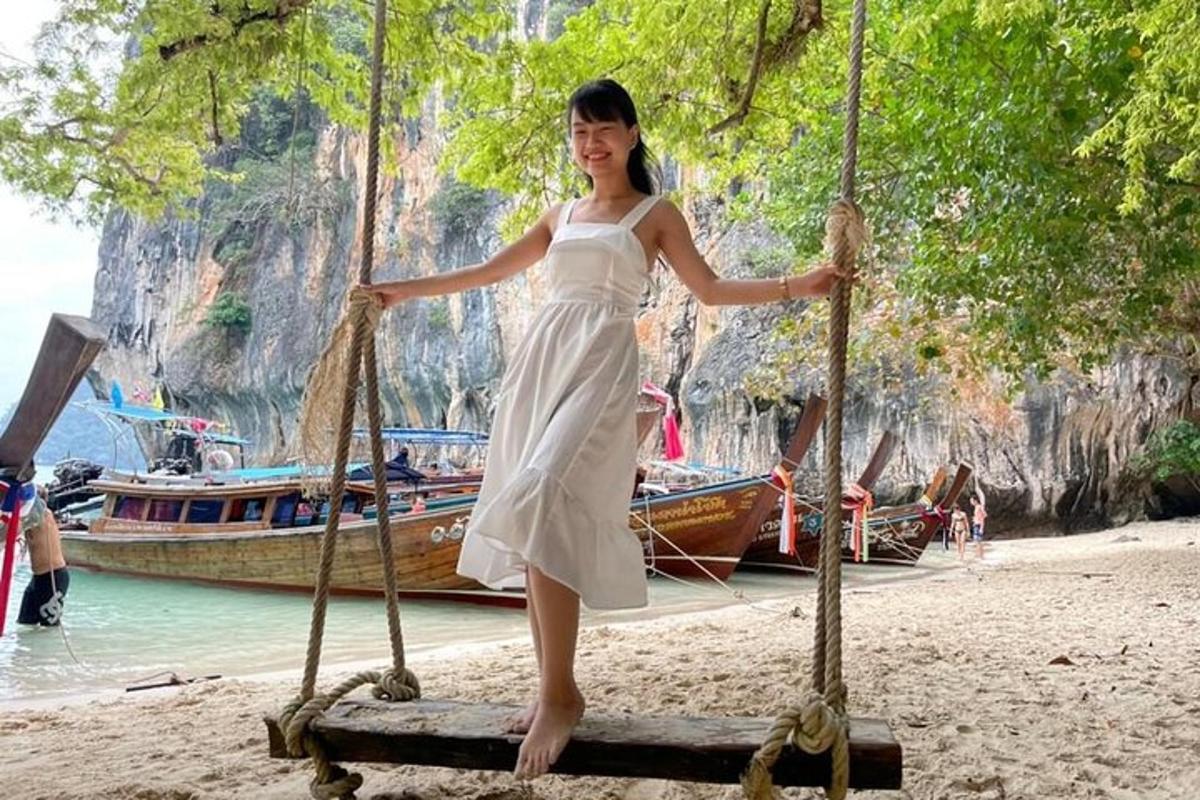 una donna in abito bianco in piedi su un ponte di legno