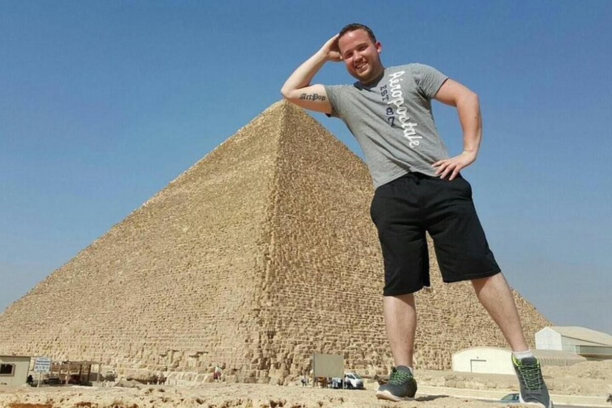 muž stojící před pyramidou