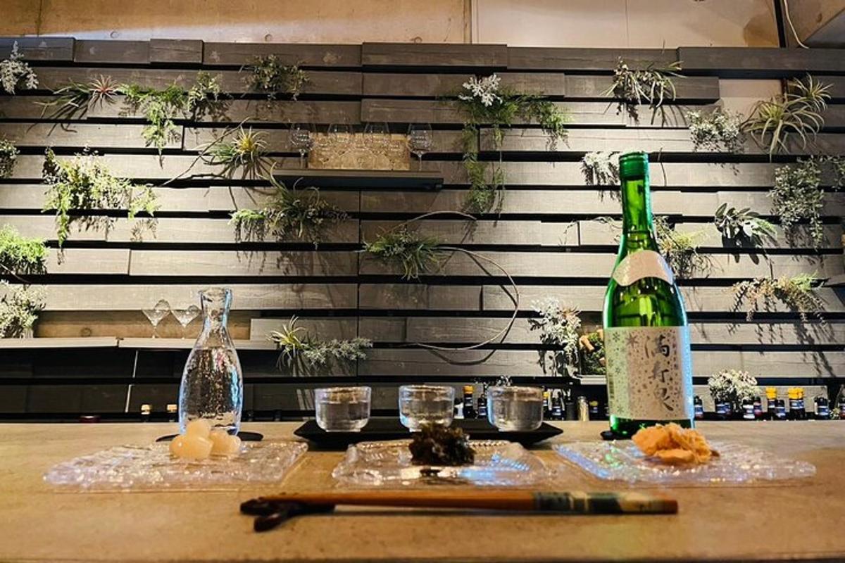 uma mesa com duas garrafas de vinho e copos