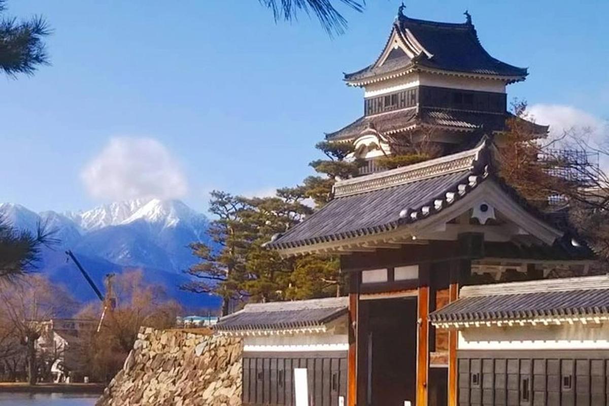 sebuah bangunan dengan menara dengan latar belakang gunung