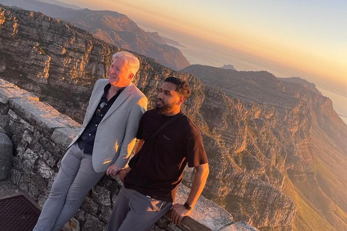 tveir menn standa á brún fjalls