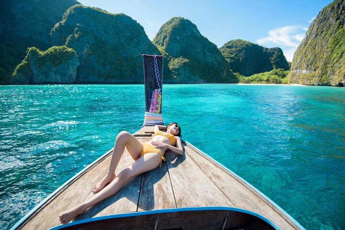 una donna sdraiata sul retro di una barca in acqua