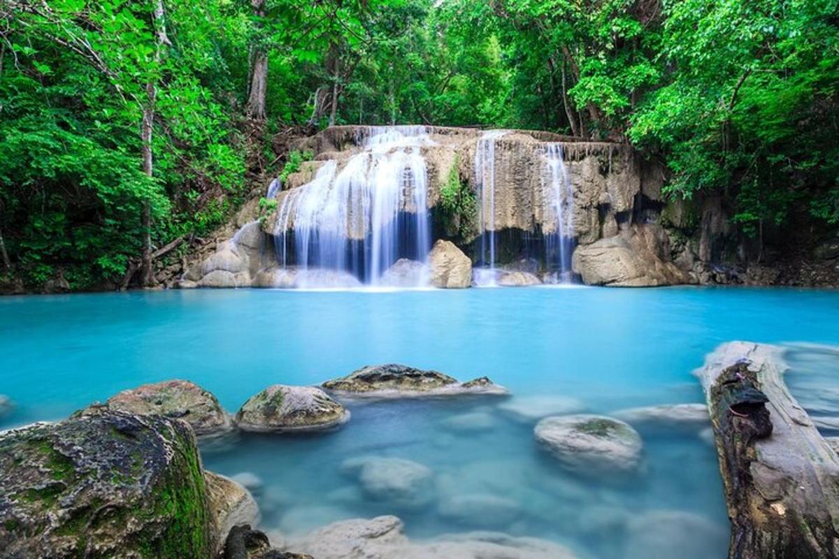 air terjun di dalam hutan dengan air biru dan batu