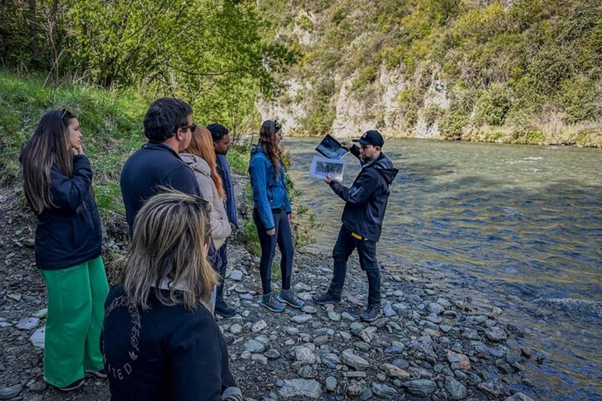 skupina lidí stojících u řeky a dívajících se na mapu