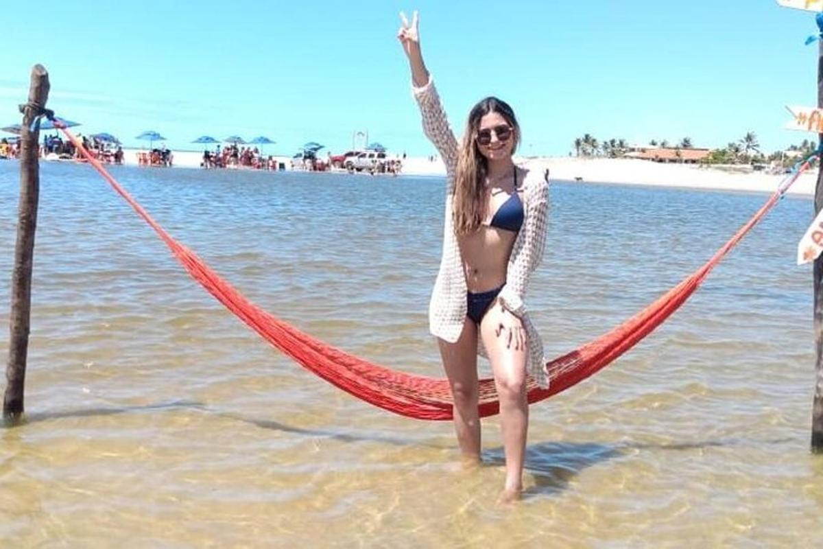 a woman standing in the water with a hammock