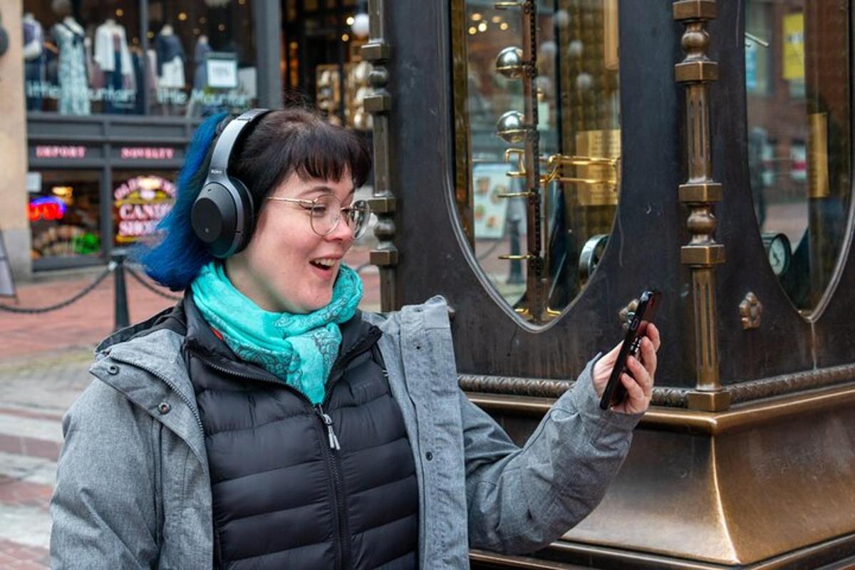 kobieta w słuchawkach i trzymająca telefon komórkowy