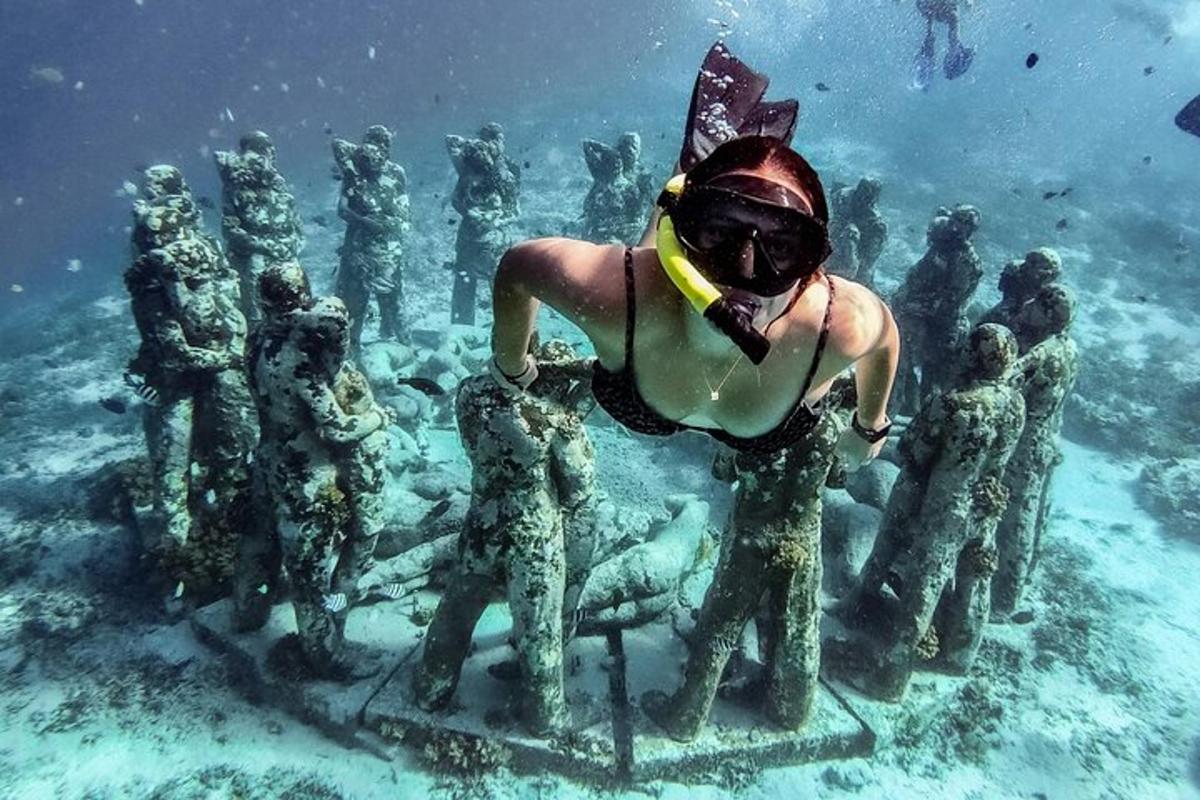 a person standing in the water next to a group of people in the ocean