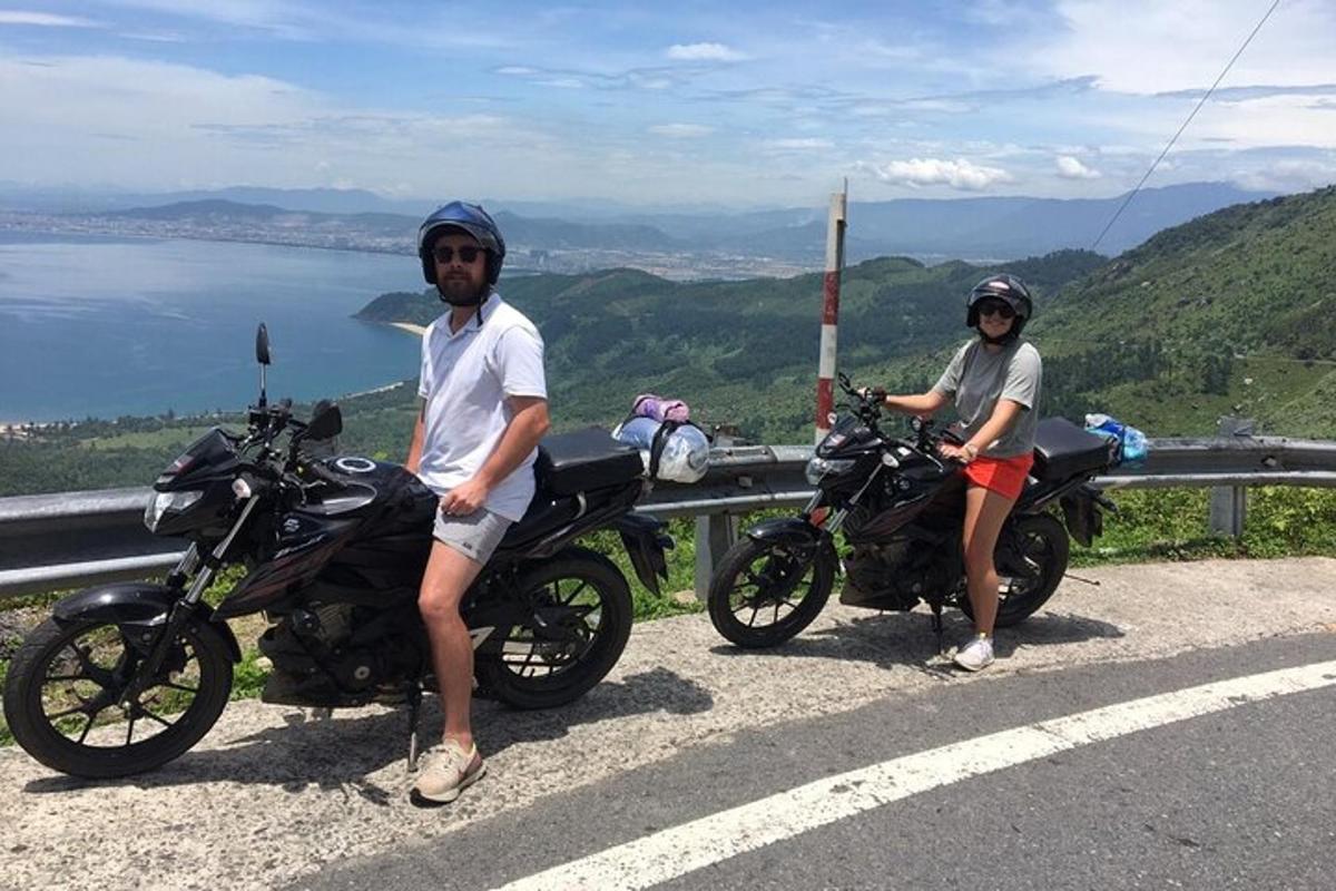 Dos personas sentadas en sus motocicletas al costado de una carretera