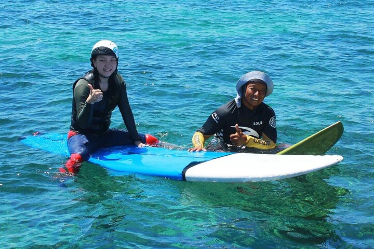due uomini sono seduti su una tavola da surf in acqua