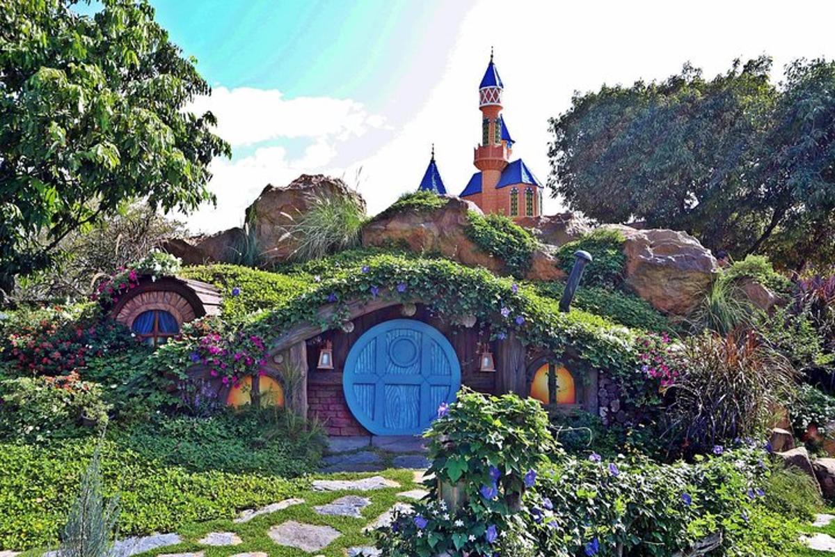 a house in a garden with a church in the background