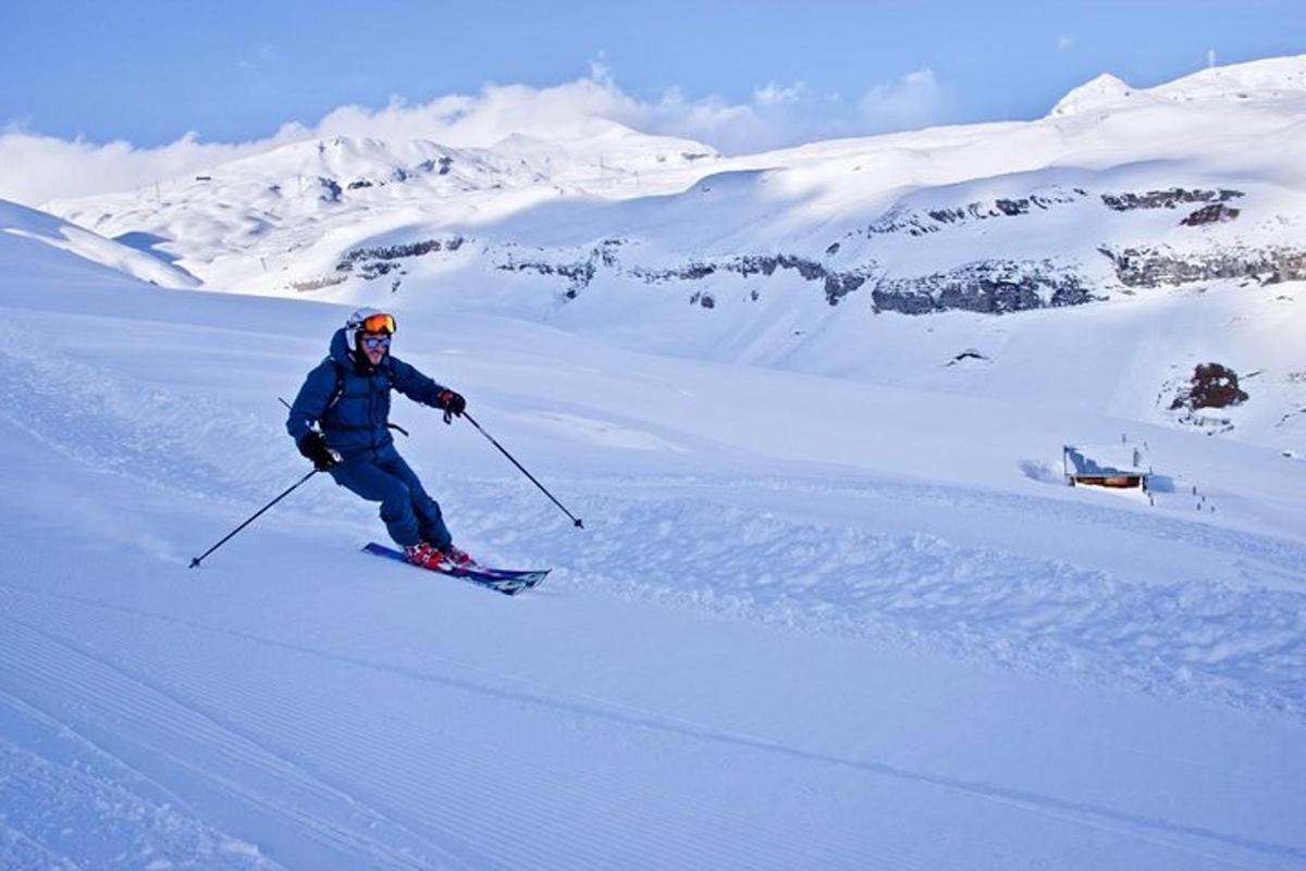 een man skiet van een met sneeuw bedekte berg