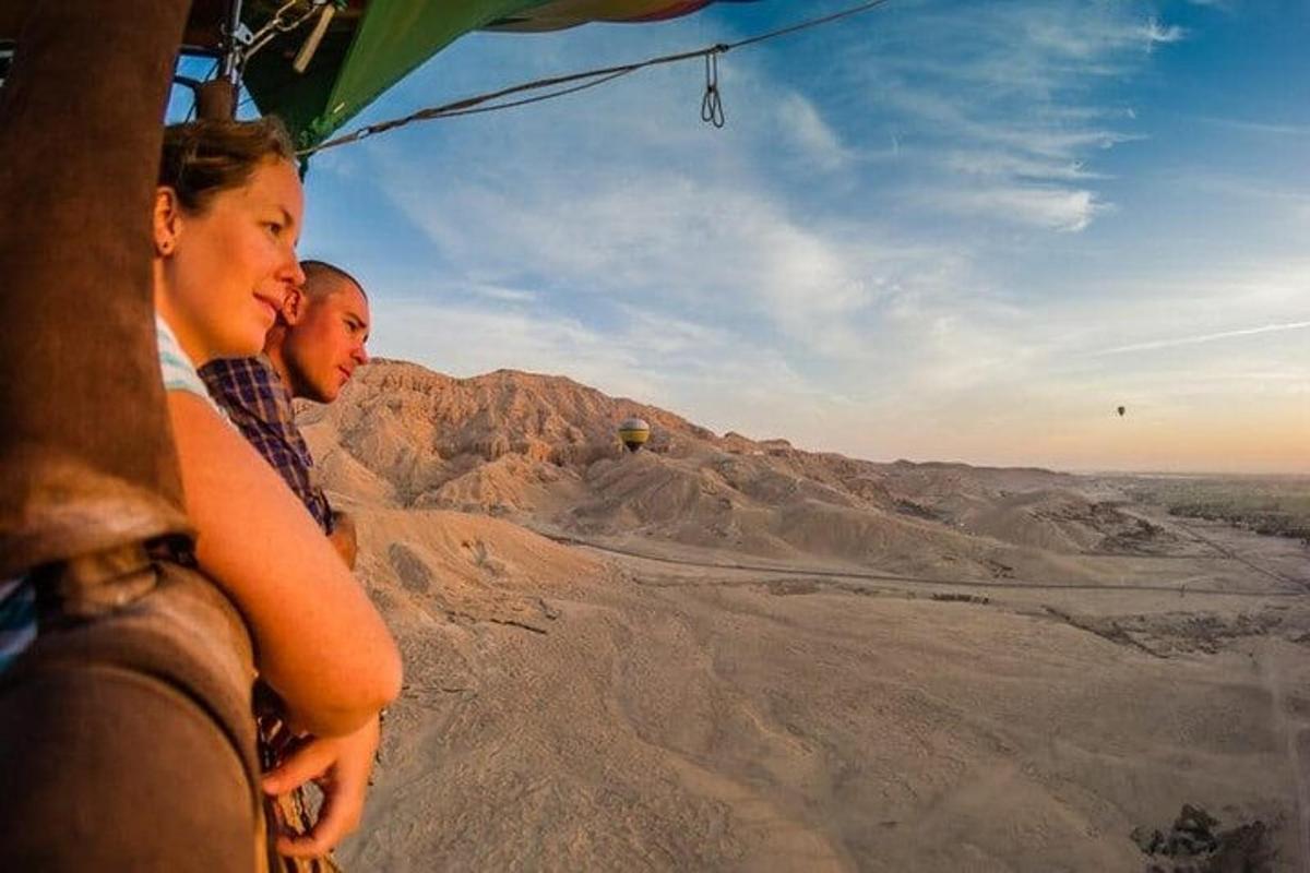 two people riding in a helicopter over the desert