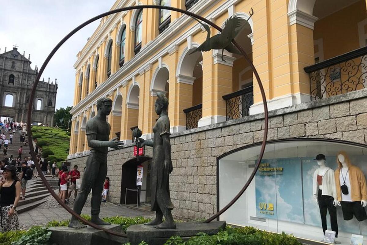 una statua di tre uomini in piedi accanto a un edificio