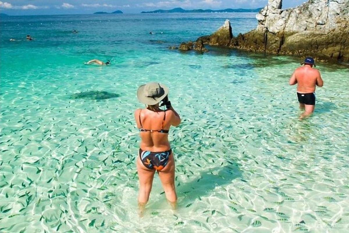 um homem e uma mulher parados na água em uma praia