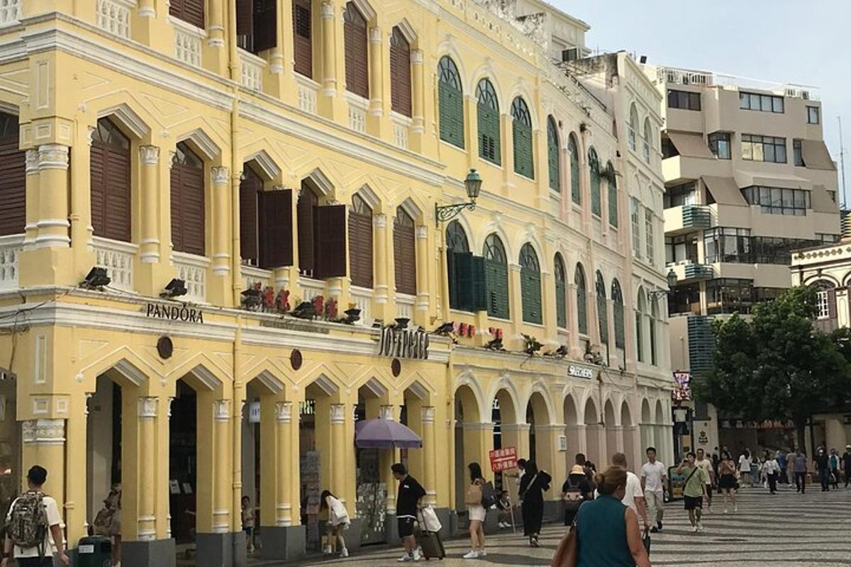 sebuah bangunan kuning dengan orang ramai berjalan di hadapannya