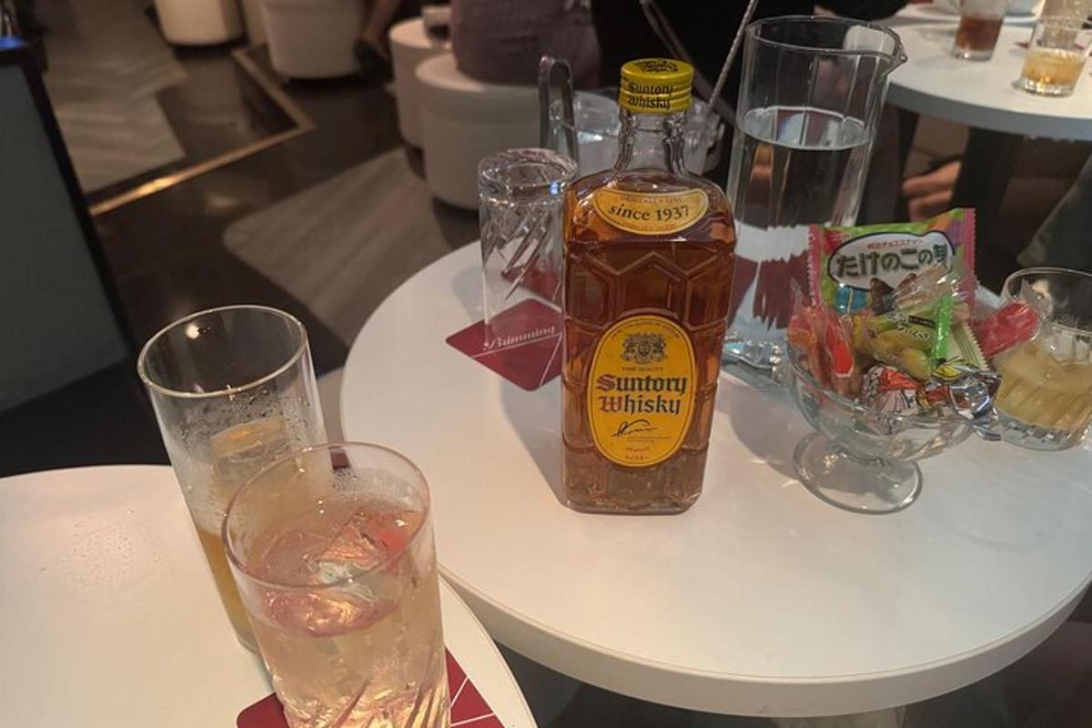 biały stół z butelką alkoholu i szklankami