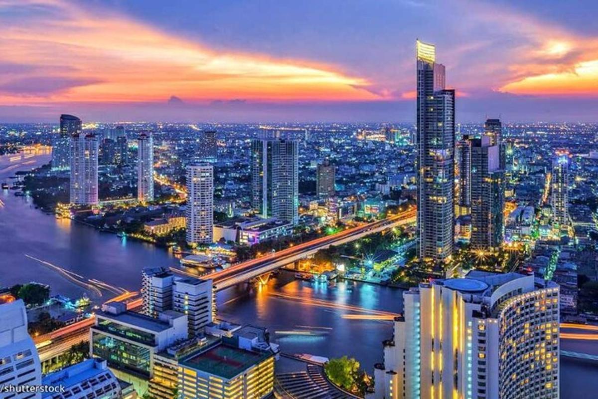 uno skyline di una città di notte con un fiume e degli edifici