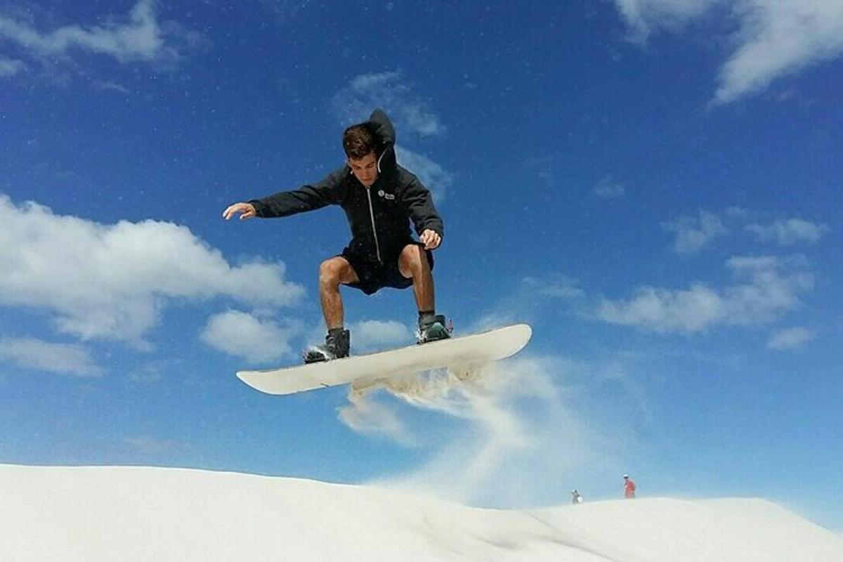 un home volant per l'aire sobre una taula de snowboard