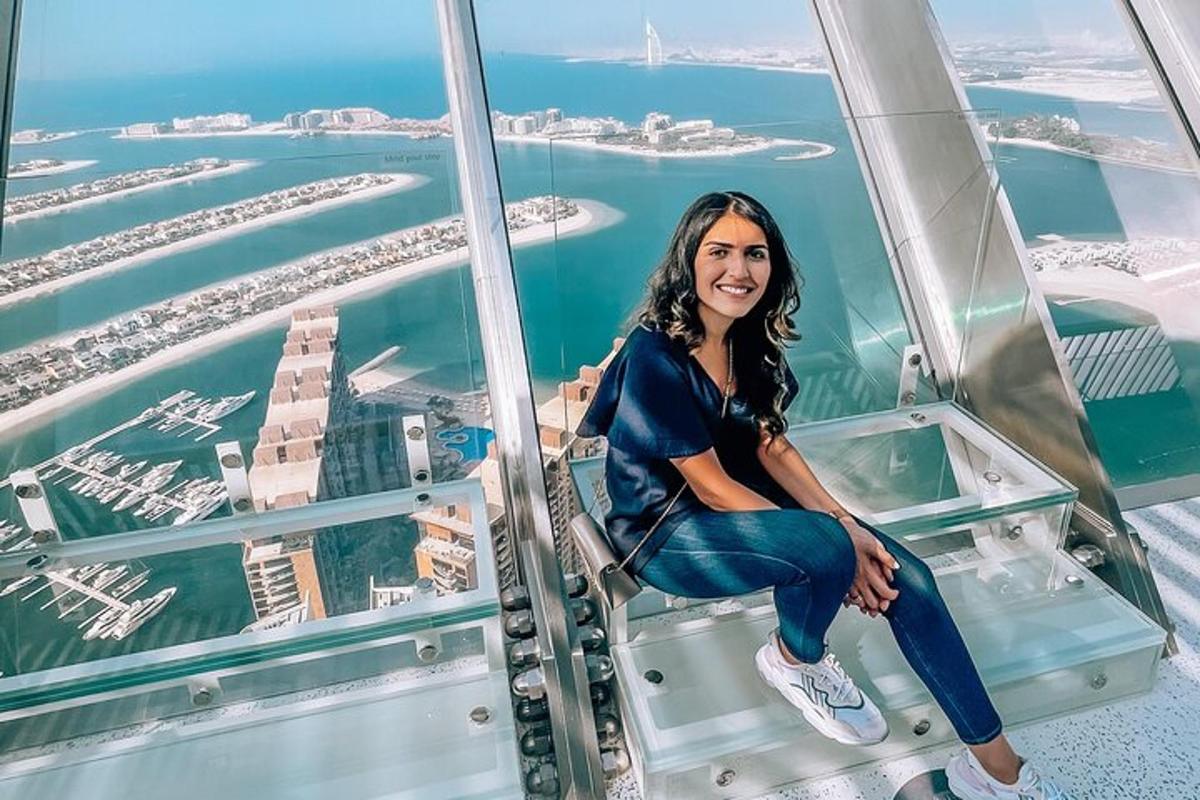 una donna seduta sul pavimento di vetro di una torre di osservazione