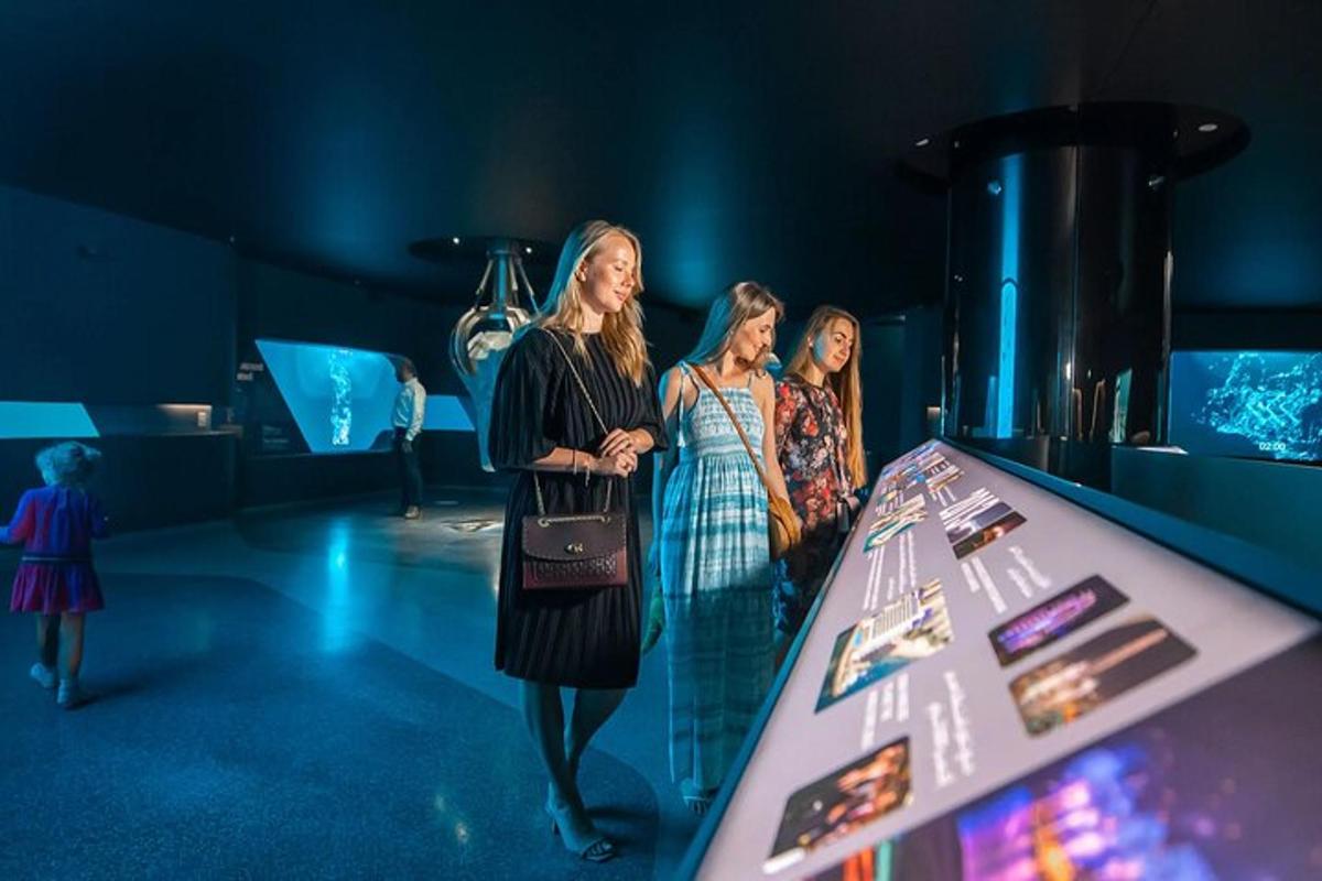 tre donne in piedi accanto a un tavolo in un museo