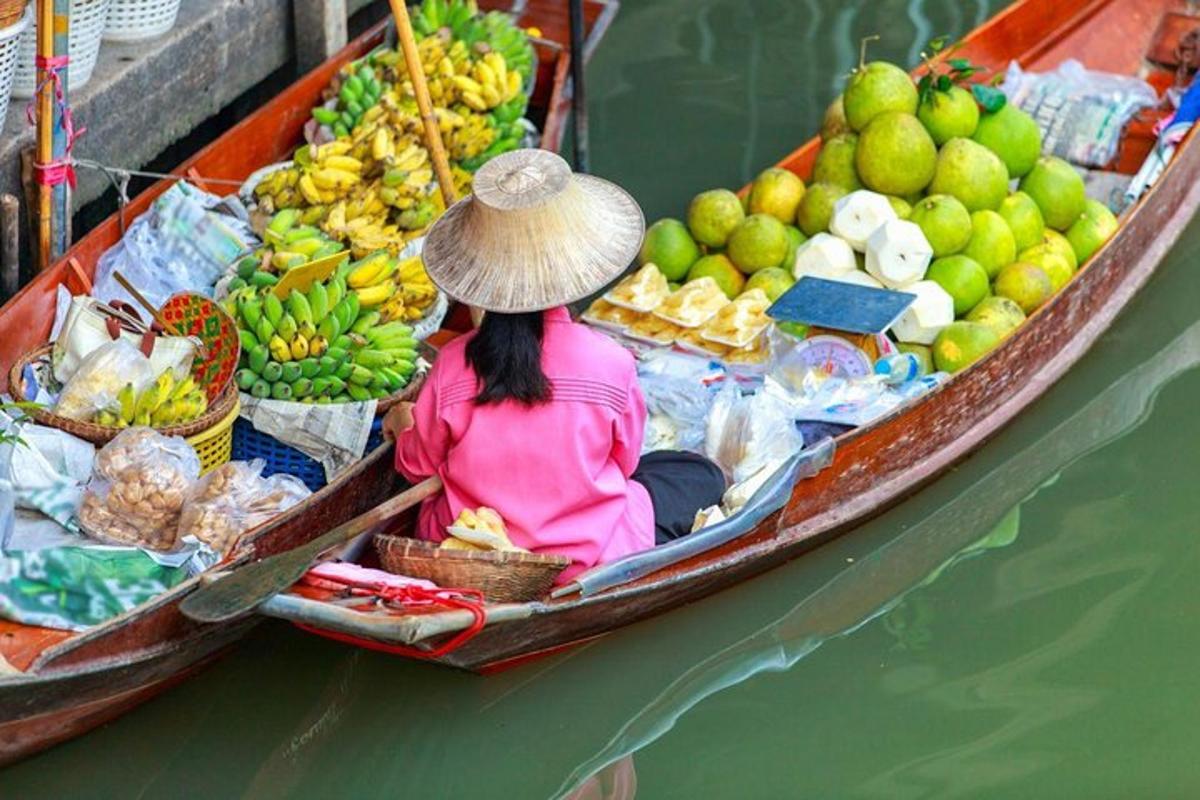 una donna seduta su una barca piena di frutta e verdura