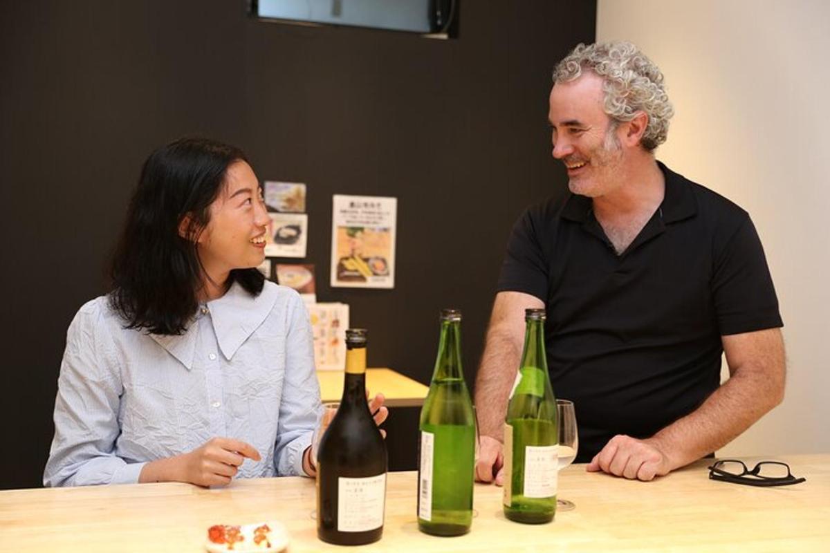 a man and a woman sitting at a table with wine bottles