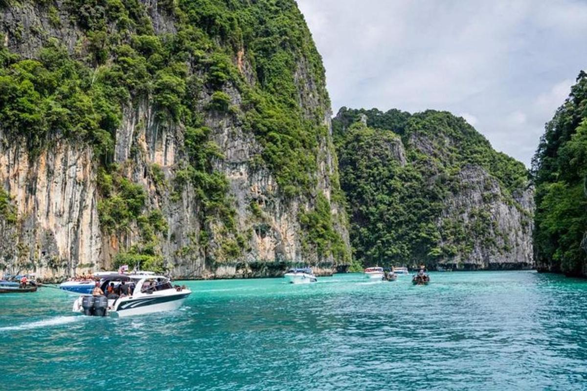 un grupo de barcos en un cuerpo de agua con acantilados