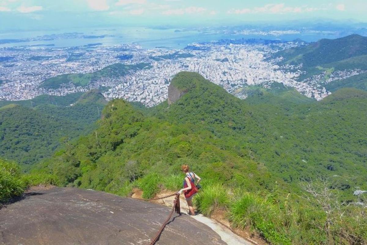 un uomo in piedi sulla cima di una montagna che domina una città