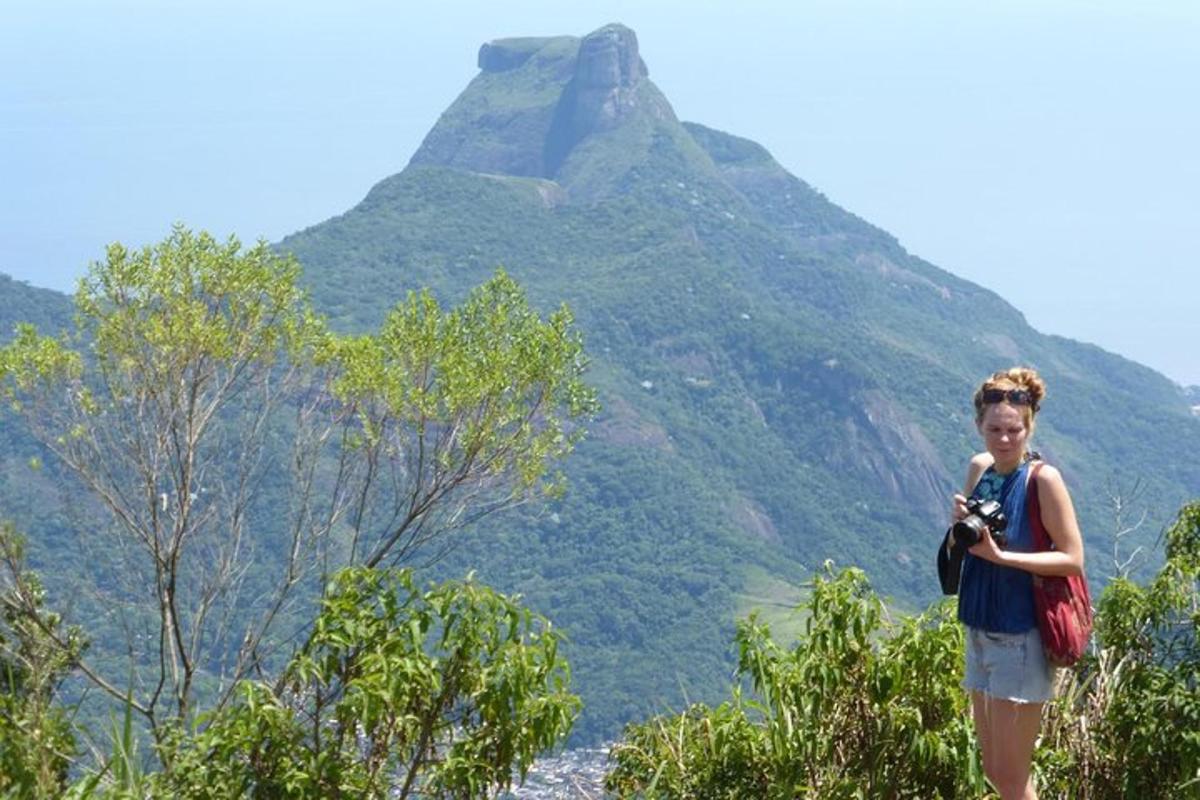 una donna che tiene una macchina fotografica davanti a una montagna
