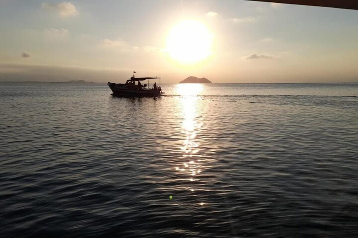 a boat in the water with the sun setting