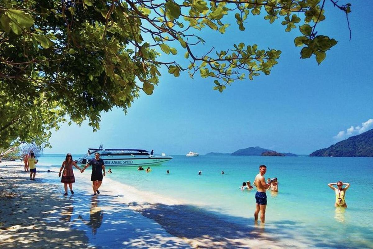 isang grupo ng mga taong naglalakad sa dalampasigan na may bangka