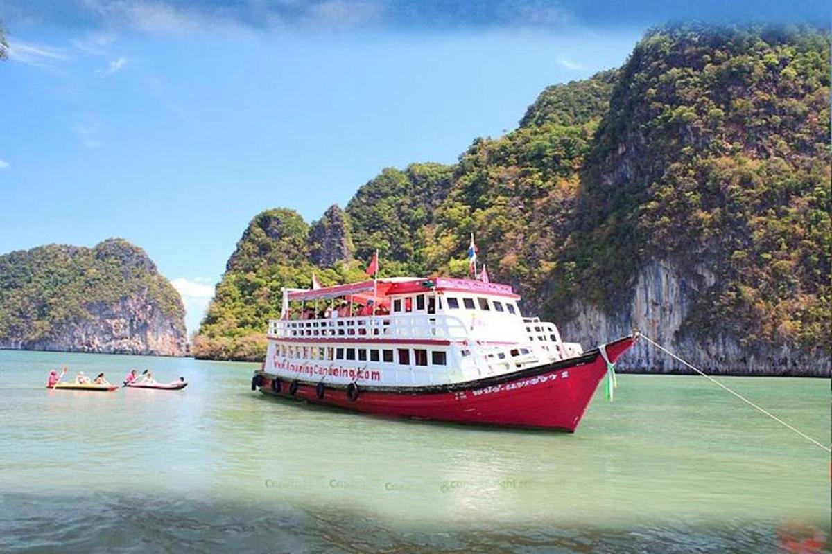 a red and white boat in the water with two boats
