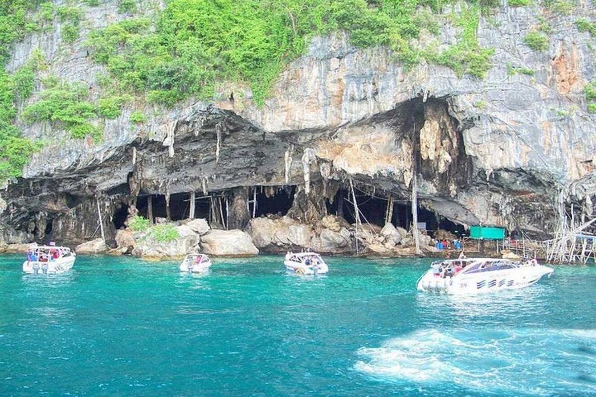 ba chiếc thuyền trên mặt nước trước một hang động