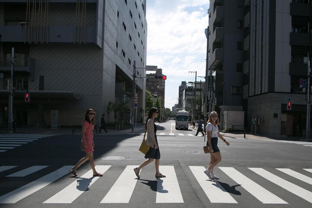 três mulheres atravessando uma rua na faixa de pedestres