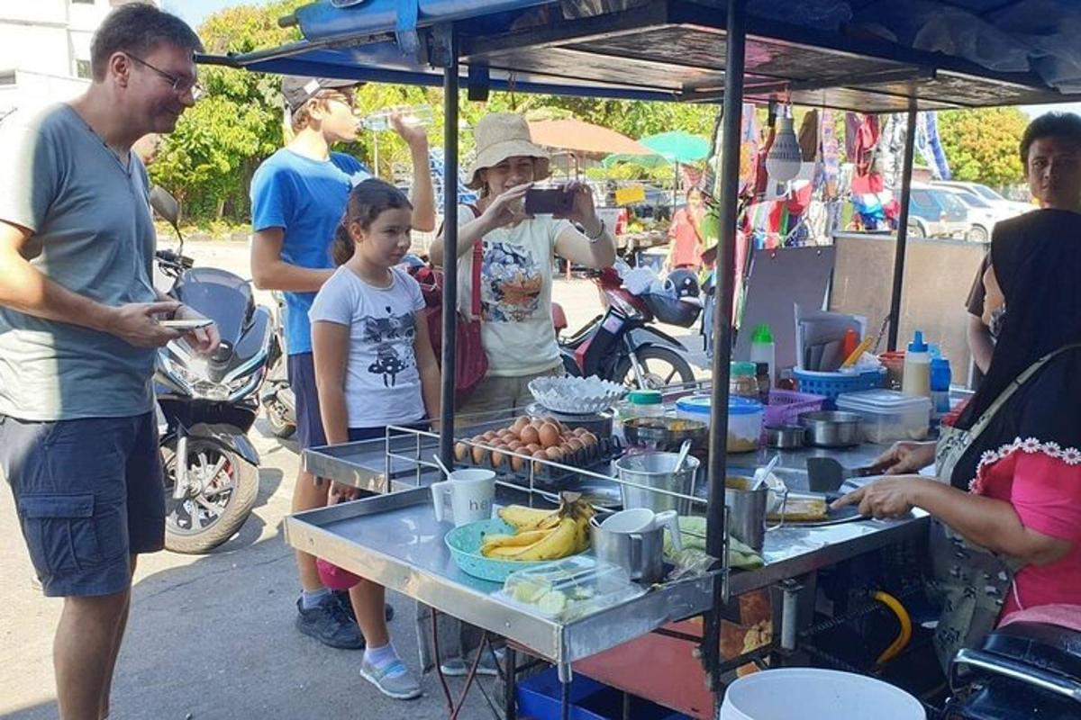 um grupo de pessoas em pé ao redor de uma barraca de comida