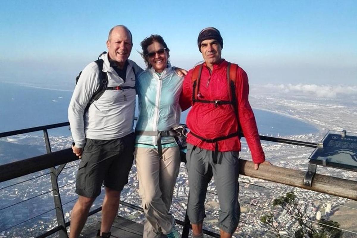 three people standing on the top of a mountain