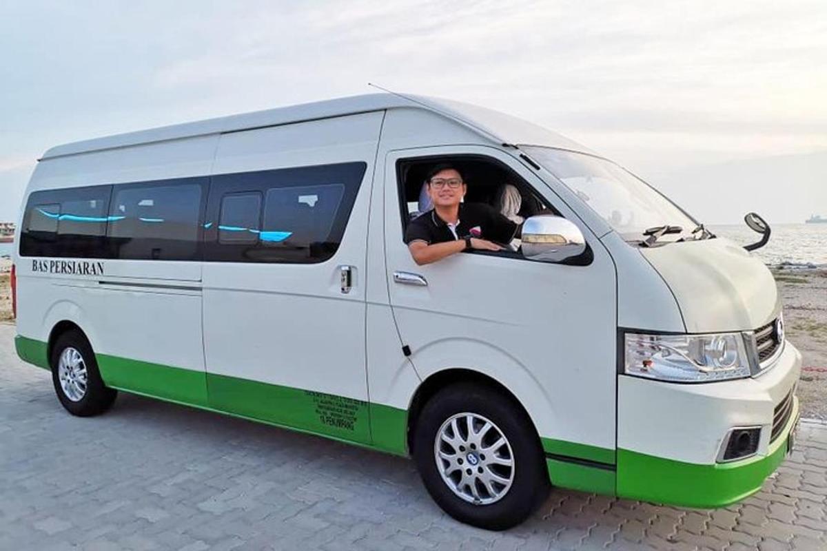 um homem está sentado em uma van branca e verde