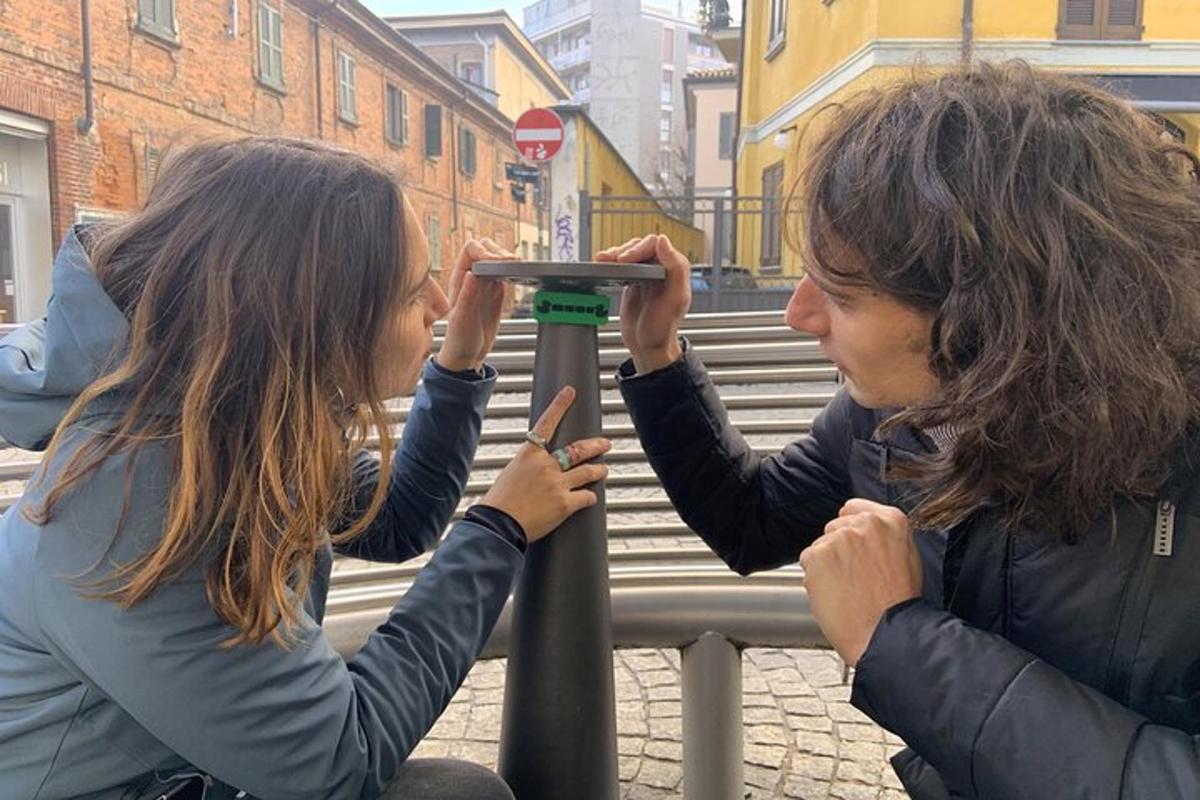 Kaksi naista katsoo tolpassa olevaa kameraa