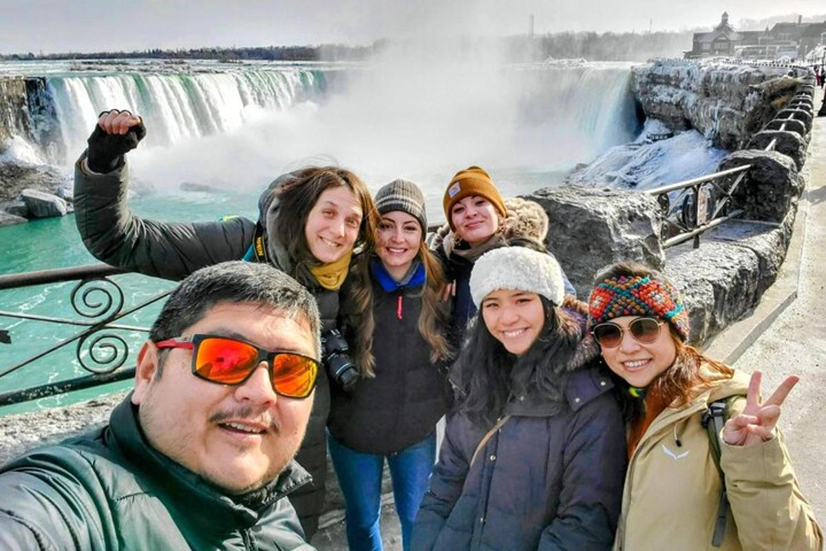 a group of people standing in front of a waterfall