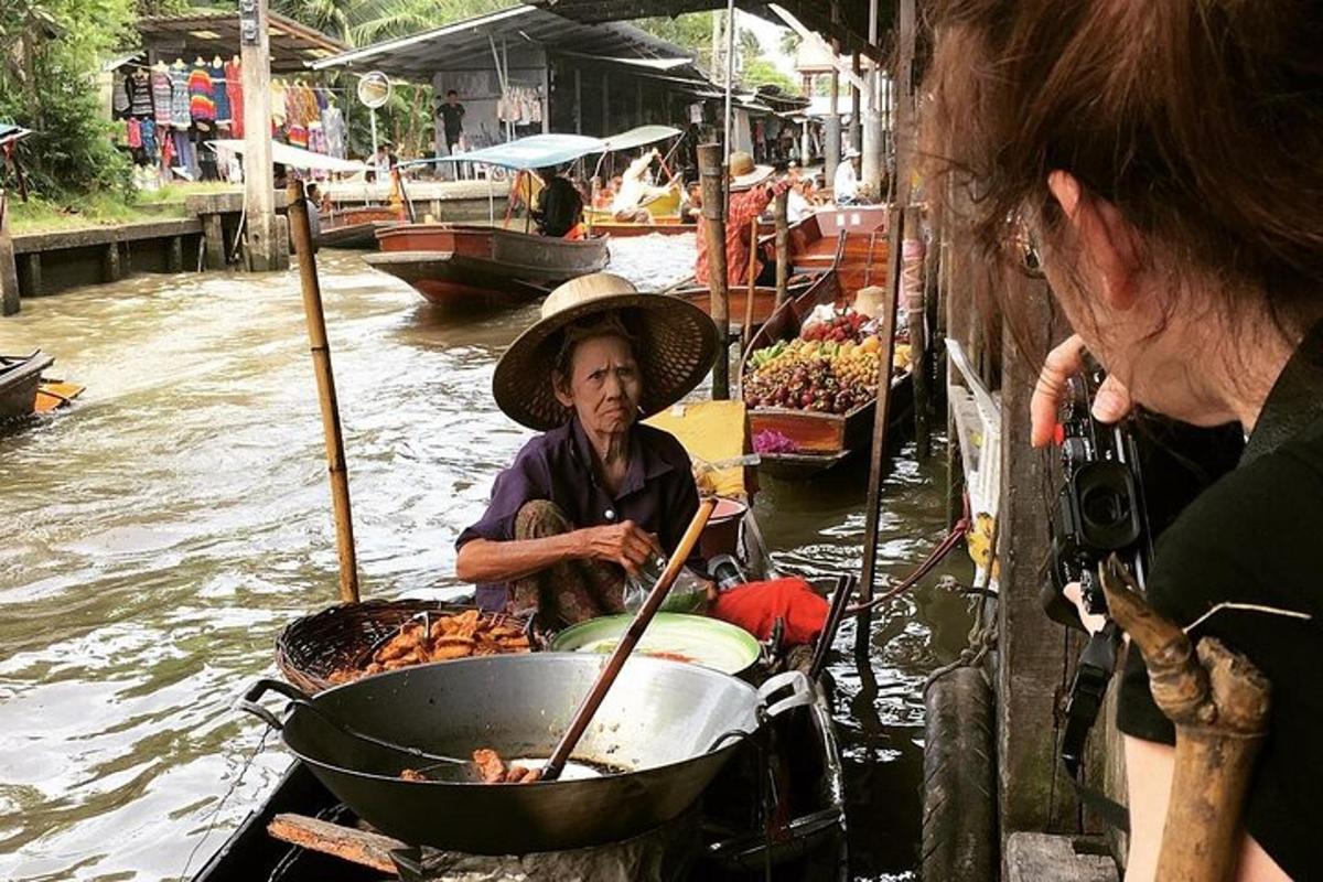 một người phụ nữ đang nấu thức ăn trong chảo trên thuyền